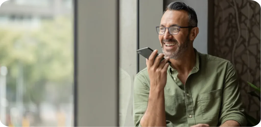 Man speaking on a cell phone while looking out of a window